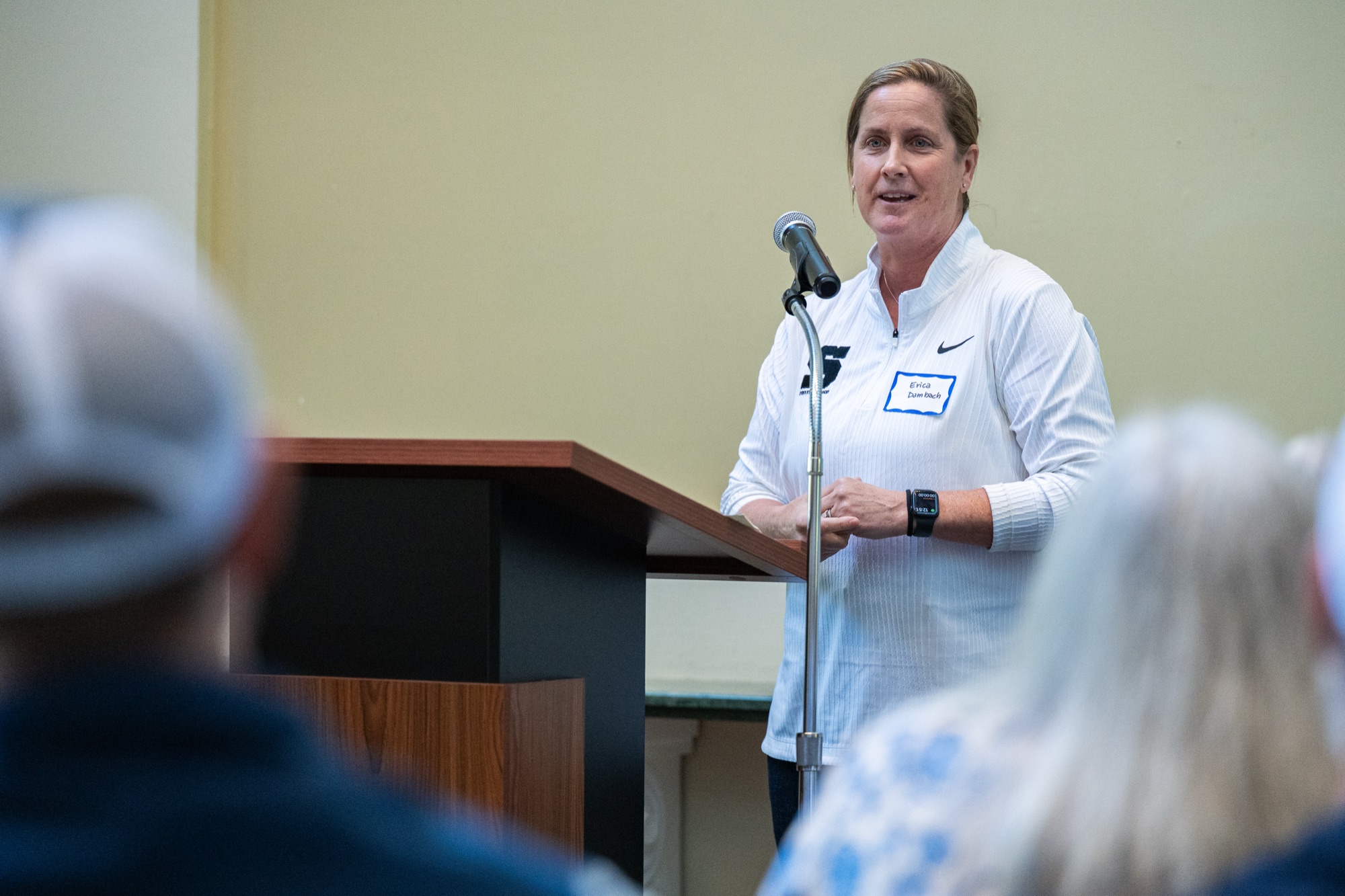 Erica Dambach speaking at a podium to student-athletes